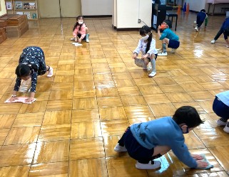 写真:床をピカピカに掃除する子どもたち