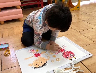 写真:経験画を画用紙に描く子ども