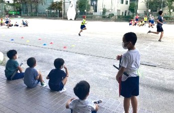 写真:運動会の練習を見つめる子どもたち