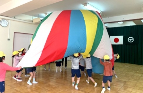 写真:バルーン遊びをする子どもたち