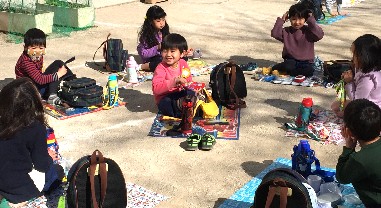 写真:お外でランチをする子どもたち