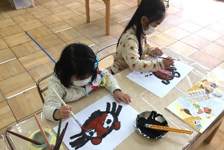 写真:お面を描く子どもたち