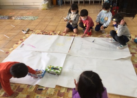 写真:大きな紙に街を描く子どもたち