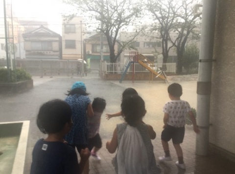 写真:土砂降りの様子を見る子どもたち
