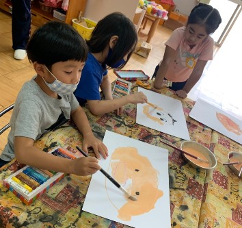 写真:自分の顔を描く子どもたち