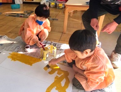 写真:家の色塗りをする子どもたち