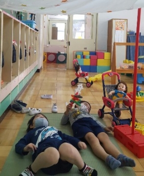 写真:床に寝転がる子どもたち