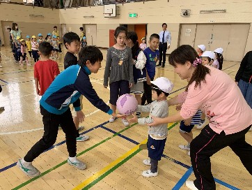 写真:お兄さんからボールを受け取る子ども