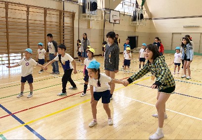 写真:5年生と手をつなぐ子どもたち