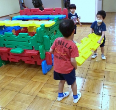 写真:大型ブロックを協力して運ぶ子どもたち
