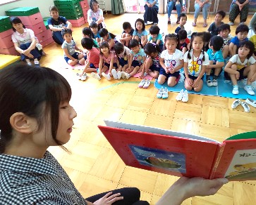 写真:絵本の読み聞かせを座って聞く子どもたち
