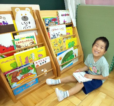 写真:好きな本を手にとって笑顔の子ども