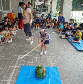 写真:スイカわりに挑戦する子ども