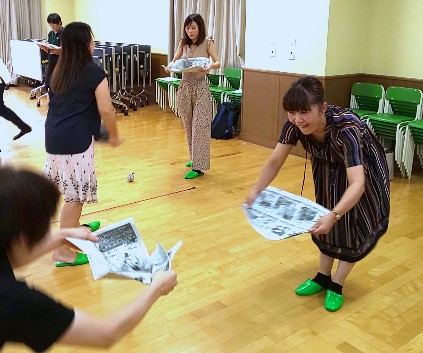 写真:新聞紙を持つ先生たち