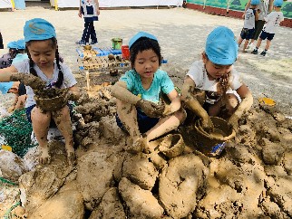 写真:泥の上に座る子どもたち