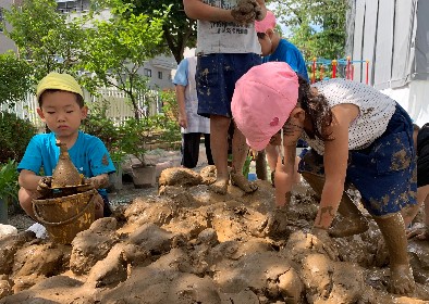 写真:泥の中に手を入れる子どもたち