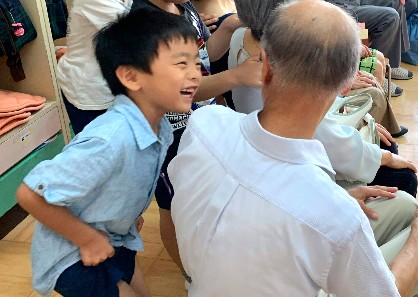 写真:おじいちゃんと笑顔で話す子ども