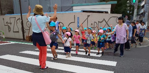 写真:手をあげて横断歩道を渡る子どもたち