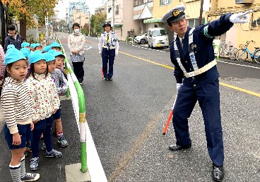 写真:お巡りさんと安全な歩行について学ぶ子どもたち