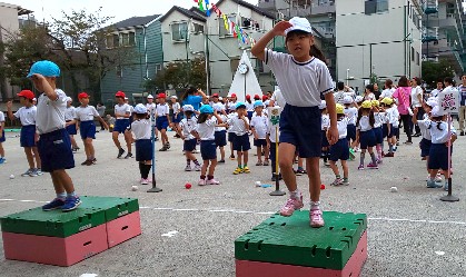 写真:台の上で敬礼をする子どもたち