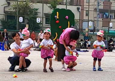 写真:先生に抱きとめられる子どもたち