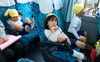 写真:バスの中でリラックスする子どもたち