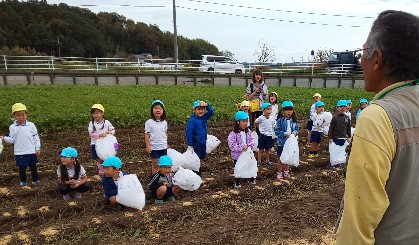 写真:農家の方の説明を聞く子どもたち