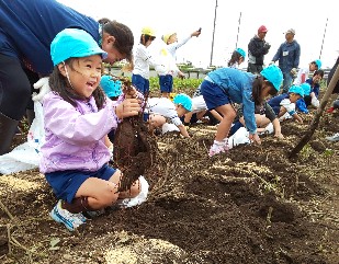 写真:大きなサツマイモに喜ぶ子どもたち