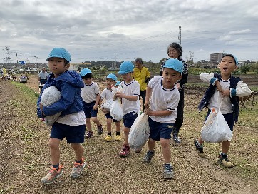 写真:重そうに運ぶ子どもたち