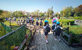 写真:湿地帯の道を歩く子どもたち