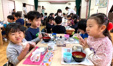 写真:おにぎりをおいしそうに食べる子どもたち