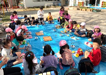 写真:広げたシートの上でお弁当を食べる子どもたち