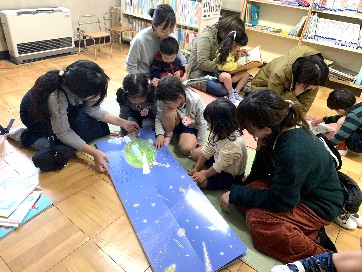 写真:大型絵本をみんなで読む子どもたち