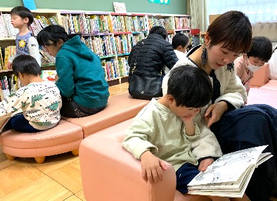 写真:お家の人に絵本を読んでもらう子どもたち