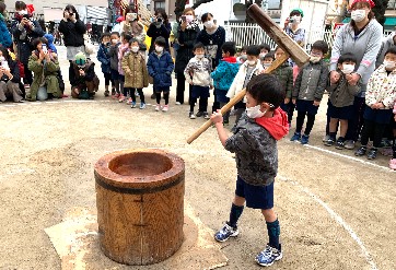 写真:自分だけの力で餅をつく子ども