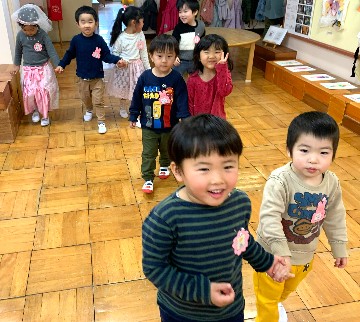 写真:新入園児と手をつないでお家の人のところまでお見送りする子どもたち