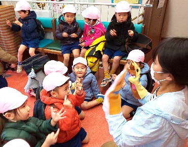 写真:先生と手遊び歌を楽しむ子どもたち
