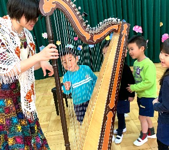 写真:アルパを触らせてもらう年長組さん