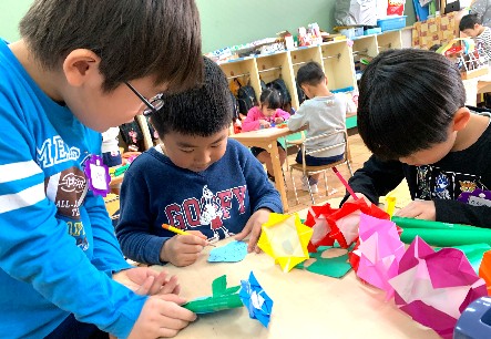 写真:折り紙で花を折る子どもたち