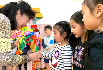 写真:折り紙の花束を渡す子ども