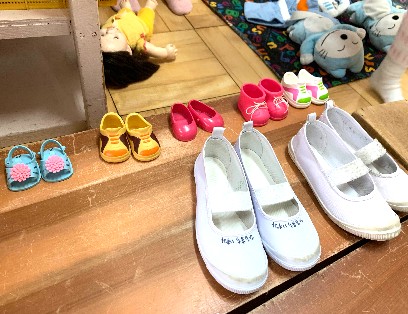 写真:お人形の靴と子どもたちの靴