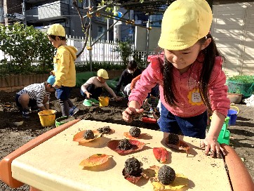 写真:砂のお団子を作る子どもたち1