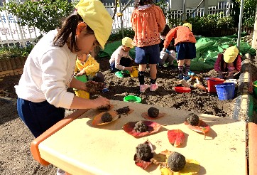 写真:砂のお団子を作る子どもたち2