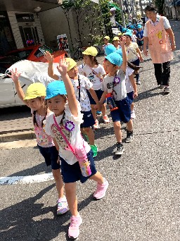 写真:手をあげて歩く子どもたち1