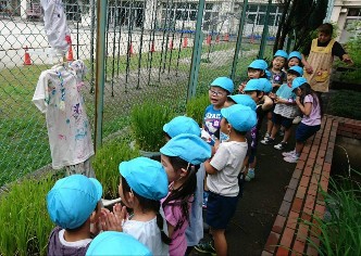 写真:かかしを見る子どもたち