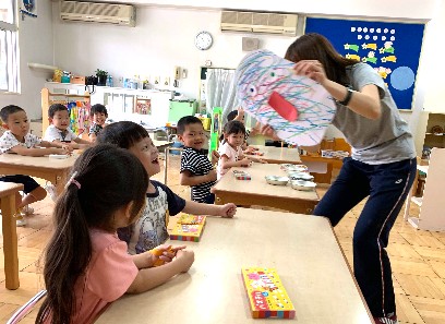 写真:お化けを持つ先生と笑顔の子どもたち