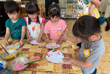 写真:思い思いに絵の具を塗る子どもたち