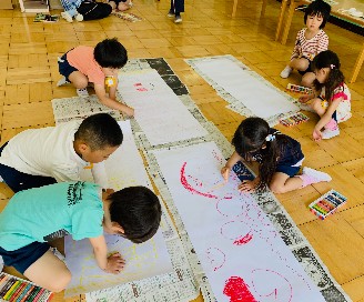 写真:大きな紙に絵を描く子どもたち