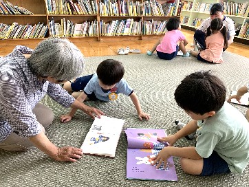 写真:司書の先生と絵本を読む子どもたち1