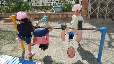 写真:鉄棒で遊ぶ子どもたち